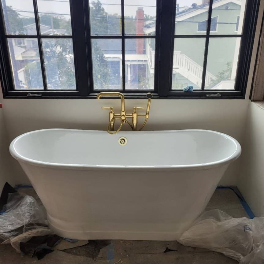 Bathroom remodel featuring freestanding tub with exposed plumbing stub-outs